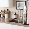 Crown Berkey Water Filter Near Kitchen Sink And Next To a Water Glass